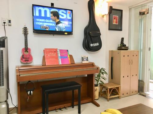 Cette chambre dispose d'un piano et d'une télévision murale. dans l'établissement Baoanh Hostel, à Hô-Chi-Minh-Ville
