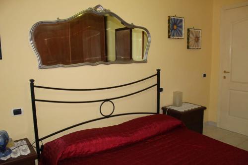 una camera da letto con un letto e uno specchio a parete di Casa PieRosa a Frosinone