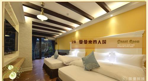 a hotel room with two beds and a television at Hsitou Man Tuo Xiang Homestay in Lugu Lake