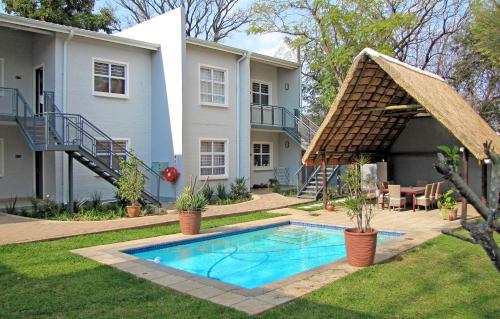 een huis met een zwembad in de tuin bij Apartments @ 125 in Gaborone