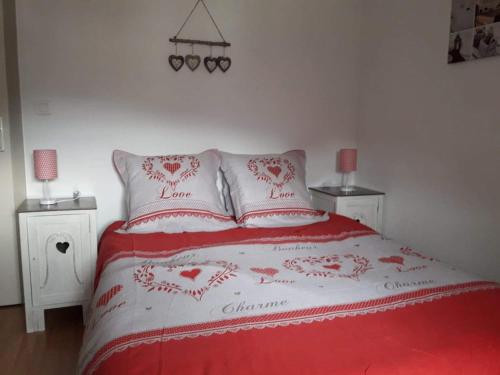 サント・マリー・オー・ミーヌにあるGite des Mines d'Argentのベッドルーム1室(赤と白のベッド1台、ナイトスタンド2台付)