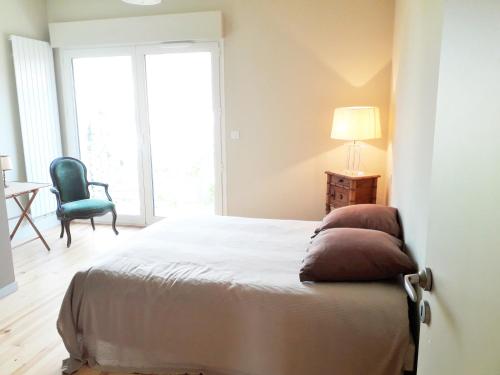 une chambre avec un lit, une chaise et une table dans l'établissement KER ARMOR Maison Moderne 3 Chambres avec Jardin, à Arcachon