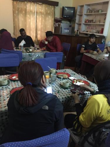 a group of people sitting at tables eating food at New United Hotel in Pokhara