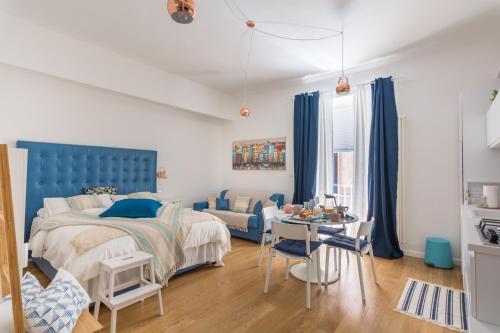 Schlafzimmer mit einem blauen Bett und einem Tisch in der Unterkunft Monolocale Casa Pepe Sorrento in Sorrent