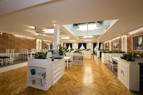 uma sala com mesas e cadeiras e vasos de plantas em Hotel Slavia em Svitavy