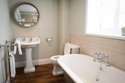 a bathroom with a sink and a toilet and a mirror at The Fox in Winchester
