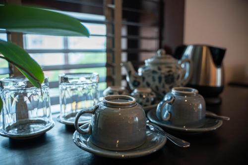 a table with three tea pots and plates on it at Phor Liang Meun Terracotta Arts in Chiang Mai