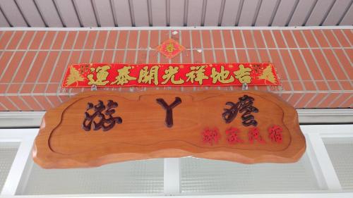 un cartel de madera con escritura china. en Grandma Yu's B&B, en Yuchi