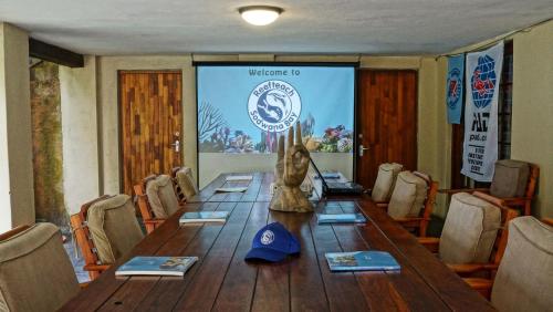 a conference room with a long wooden table with chairs at Reefteach Lodge in Sodwana Bay