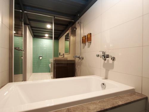 a white bath tub in a bathroom with a shower at Anson 19 B&B in Lugang