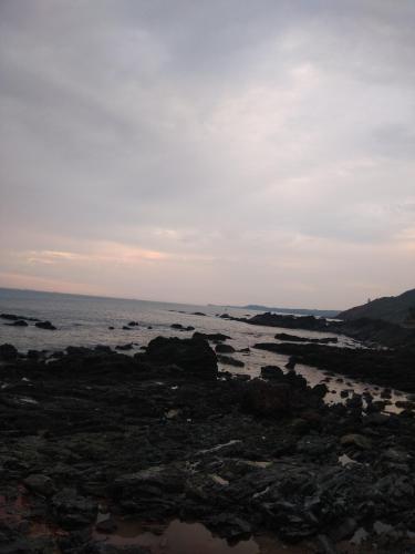 a view of the ocean from a rocky beach at Om Ganesh Naik Guest House in Arambol
