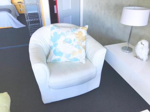 a white chair with a pillow in a room at Tamar River Apartments in Rosevears