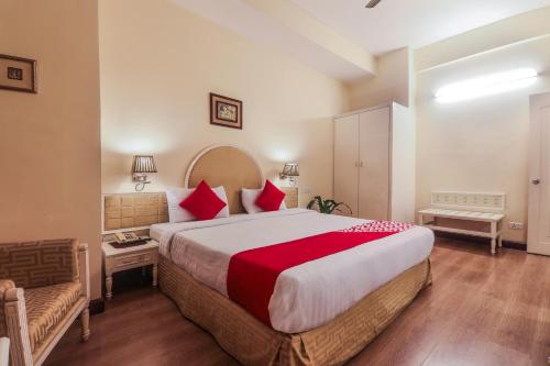 a bedroom with a large bed with red pillows at Alpine Continental in Shillong