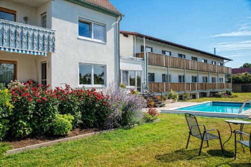 a house with a yard with a swimming pool at Hotel-Pension Seitz in Wolframs-Eschenbach