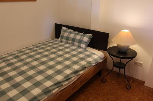a small bedroom with a bed and a table with a lamp at Apartment Rietheim in Rietheim-Weilheim