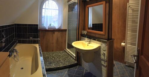 a bathroom with a sink and a bath tub and a sink at Maison de vacances à Kertzfeld in Kertzfeld