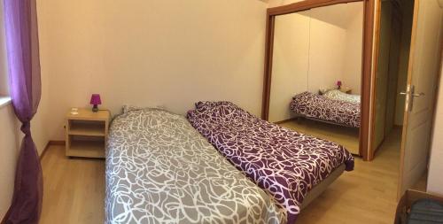 une chambre avec un lit et un grand miroir dans l'établissement Maison de vacances à Kertzfeld, à Kertzfeld