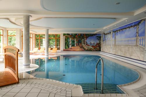 a swimming pool in a house with a painting on the wall at Hotel Kogler in Bad Mitterndorf