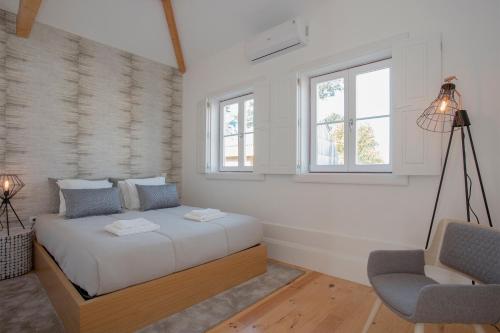 a bedroom with a bed and a chair and a window at Liiiving in Porto | Historic & Sunny Terrace in Porto