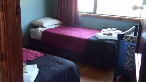 a small room with two beds and a window at Kepler Oaks Chalet in Te Anau