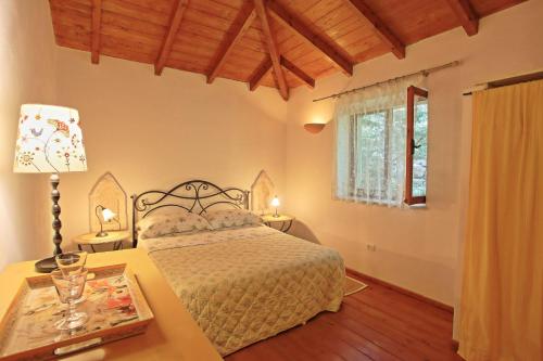 a bedroom with a bed and a table with a lamp at Kitrini Luxury Cottage in Zenempisátika