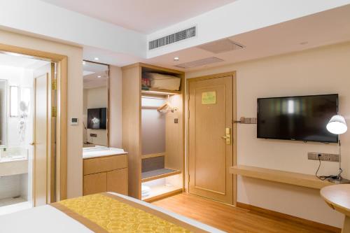 a hotel room with a television and a bathroom at Vienna International Hotel Xi'an Dayan Tower in Xi'an