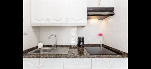 a kitchen with white cabinets and a sink at Playa Nieves in Puerto Naos