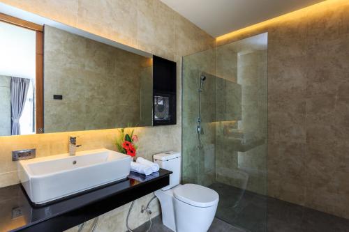 La salle de bains est pourvue d'un lavabo, d'une douche et de toilettes. dans l'établissement Sunnyvale Ranong 1, à Ranong