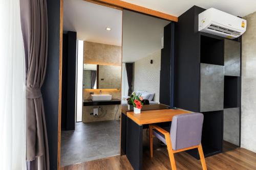 Un comedor con una mesa y un espejo. en Sunnyvale Ranong 1, en Ranong