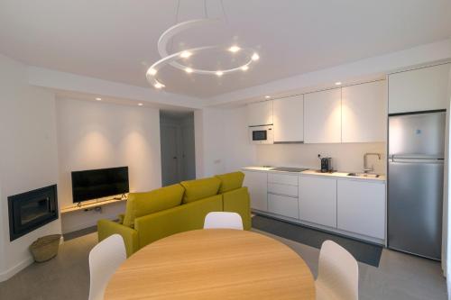 a living room with a yellow couch and a kitchen at La Pomera in Vilaller