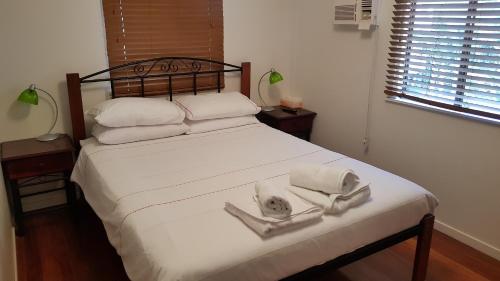 een slaapkamer met een bed met een hoed erop bij Cedar Lookout in Brisbane
