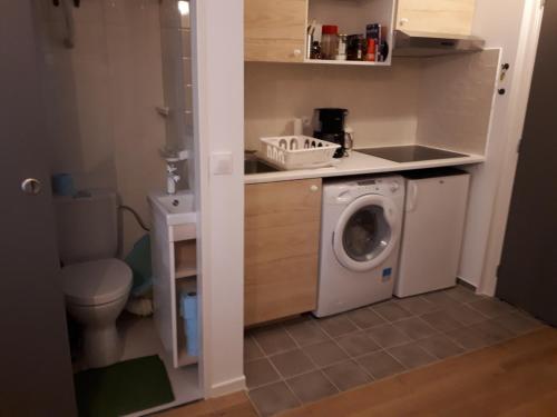 une petite salle de bains avec un lave-linge. dans l'établissement La Touques, à Trouville-sur-Mer