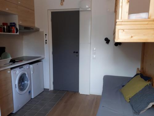 une cuisine avec une machine à laver dans une pièce dans l'établissement La Touques, à Trouville-sur-Mer