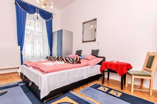 sypialnia z dwoma łóżkami, stołem i krzesłem w obiekcie Arany Csillag Apartman w Egerze