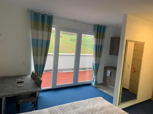 a bedroom with a bed and a large window at Hotel Am Spielacker in Gelnhausen