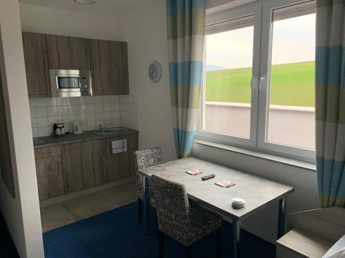 eine kleine Küche mit einem Tisch und einem Fenster in der Unterkunft Hotel Am Spielacker in Gelnhausen