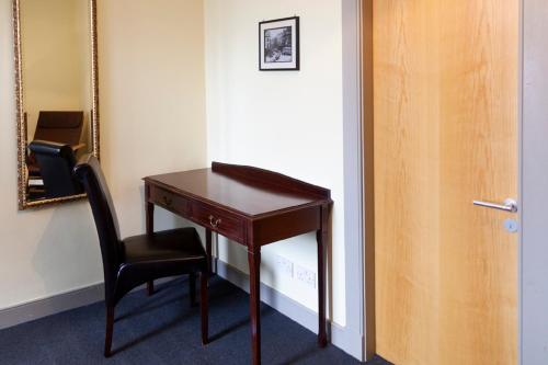 a desk and a chair next to a door at Dundee Backpackers Hostel in Dundee