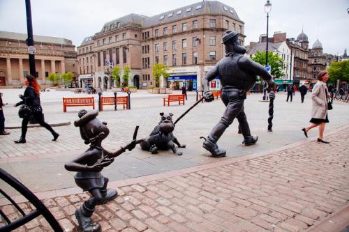 a statue of two children playing with two statues at Dundee Backpackers Hostel in Dundee