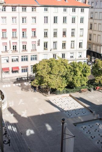 a large white building with a tree in front of it at Hôtel Des Artistes in Lyon