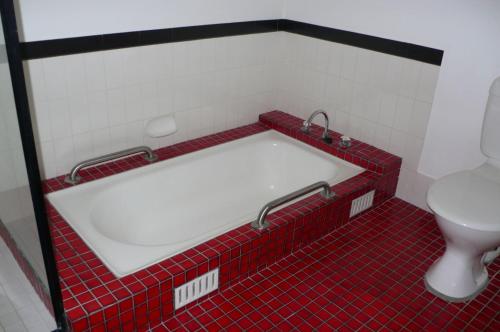 a bath tub in a bathroom with a toilet at SPLASH in Elizabeth Beach