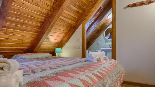 1 dormitorio con 1 cama con techo de madera en Saplan Real Estate MONTLUDE, en Les