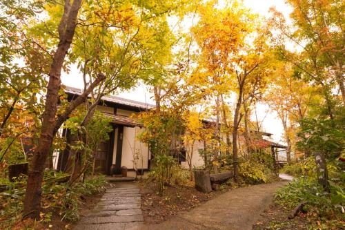 a house surrounded by trees in the fall at Shinwaen in Aso
