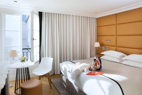 a hotel room with a bed and a table at Hôtel R de Paris - Boutique Hotel in Paris