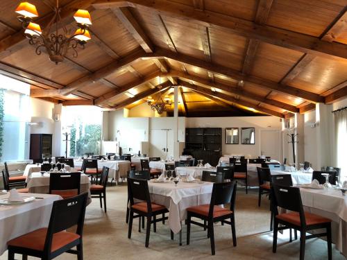 uma sala de jantar com mesas e cadeiras brancas em Hotel Convento Del Giraldo em Cuenca