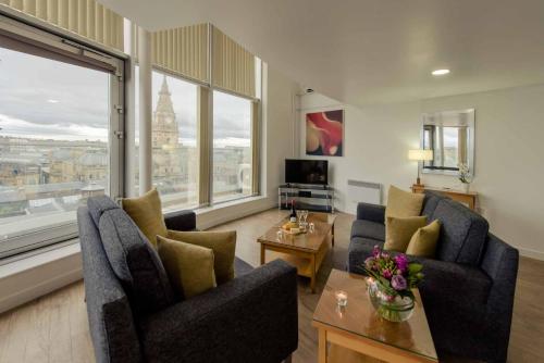 a living room with two chairs and a large window at PREMIER SUITES Liverpool in Liverpool
