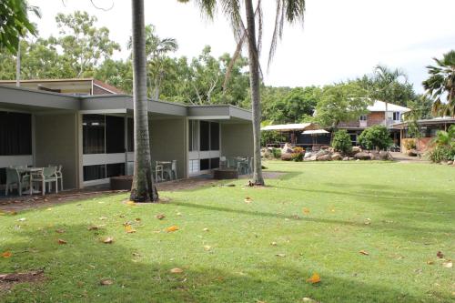 a house with a green yard with palm trees at Arcadia Village Motel in Arcadia