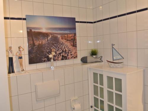 ein Regal in einem Bad mit einem Bild an der Wand in der Unterkunft Kaiserhof Apartment 14 in Wangerooge