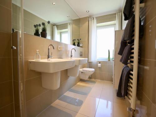 a bathroom with a sink and a toilet at Parkoase in Wangerooge