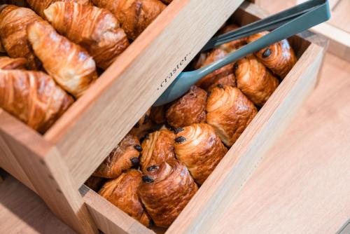 two wooden boxes filled with croissants on a table at ibis Styles Carcassonne La Cité in Carcassonne