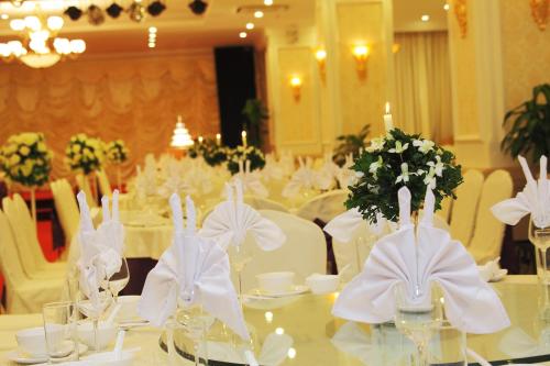 a dining room with white tables and white chairs at Ha Long DC Hotel in Ha Long